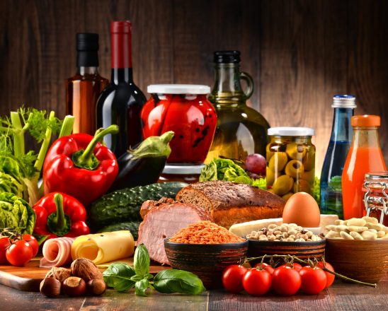 Composition with variety of organic food products on kitchen table