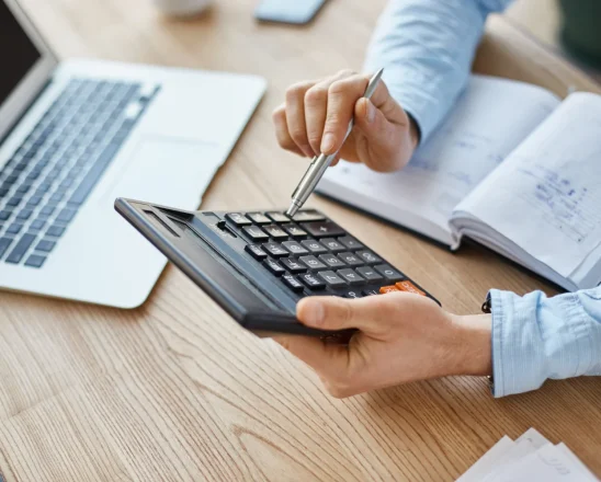 cropped-view-professional-serious-finance-manager-holding-calculator-hands-checking-company-month-s-profits